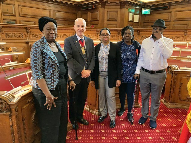 4 members of the Thamesmead Delivery team standing with the Greenwich Mayor in the Council Chambers of the Town Hall.
